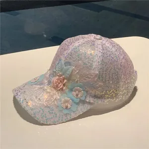Detail view of sequins baseball cap with 3D floral lace and pearl embellishments
