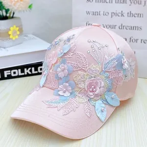 Detailed macro view of pink satin baseball cap featuring 3D floral embroidery and pearls