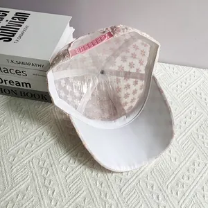 Dettaglio del cappellino rosa in pizzo floreale con struttura interna e cinturino