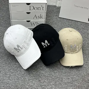 Distressed baseball caps with rhinestone M letter in white, black and khaki colors