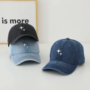 Detailed view of washed denim baseball caps in three shades with metallic star accents