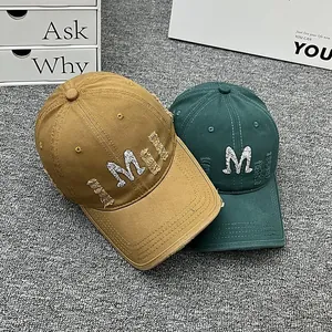 Distressed baseball caps with rhinestone M logo in ginger and dark green colors