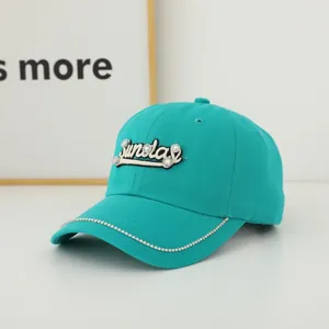 Detailed view of rhinestone Sunday embroidery and crystal trim on teal baseball cap