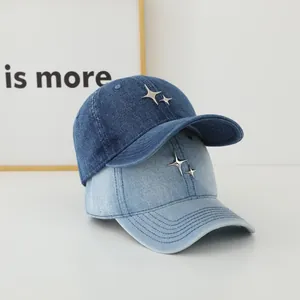 Detail of blue denim baseball caps featuring silver metal star studs and soft top design