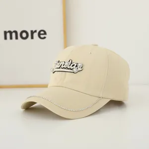 Close-up of beige baseball cap with rhinestone brim chain and 3D Sunday embroidery