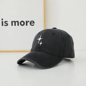 Detail of washed denim baseball cap featuring two silver metallic star-shaped ornaments