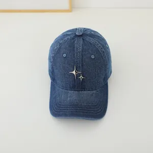 Detailed macro of washed dark blue denim baseball cap with silver metal star badges