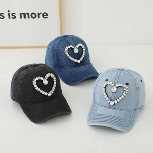 Detailansicht von Denim-Baseballkappen in drei Farben mit Strass-Herz-Verzierungen
