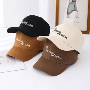 Detail of embroidered lettering on cotton baseball caps in various earthy tones