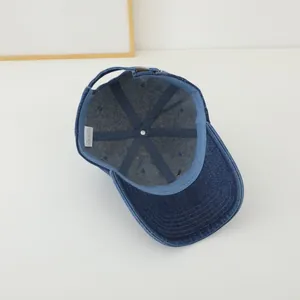 Interior detail of washed denim baseball cap showing cotton label and stitching