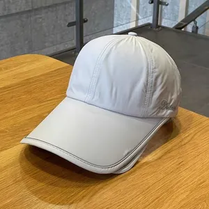 Detail of solid color baseball cap featuring elegant cursive embroidery on the side