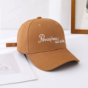 Close-up of 'Per aspera ad astra' white embroidery on a brown cotton baseball cap