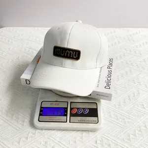 Detail of white baseball cap weighing 115g on scale showing lightweight material