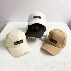 Detailed view of mumu letter patches on baseball caps in white, black and beige colors
