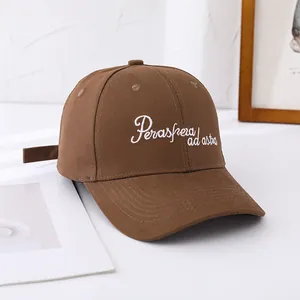 Close-up of brown cotton baseball cap featuring white Per aspera ad astra embroidery