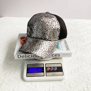 Silver geometric texture baseball cap on digital scale showing a weight of 9.0 oz