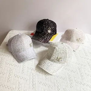 Detail view of lace baseball caps with sparkling rhinestones and maple leaf crystal accents