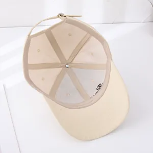 Detailed view of beige cotton baseball cap interior with mesh lining and metal buckle