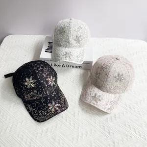 Détails de dentelle avec fleurs en strass et logo KISS sur des casquettes de baseball