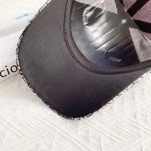 Detailed close-up of the black mesh cap interior and brim showing fabric texture
