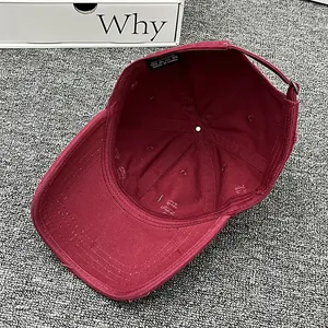 Macro detail of wine red washed cotton baseball cap with adjustable metal buckle back