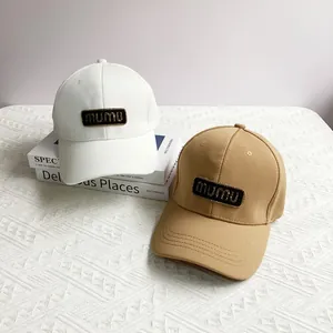 Close-up of baseball caps with mumu logo patch on textured fabric background