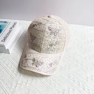 Detailed view of pink lace baseball cap featuring sparkling rhinestone butterfly and LOVE motifs