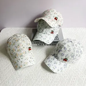 Detailed view of three floral baseball caps with 3D cherry accents and lace textures