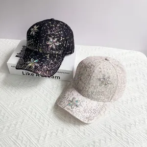 Casquette en dentelle avec trèfle en strass et lettrage KISS en noir et beige clair