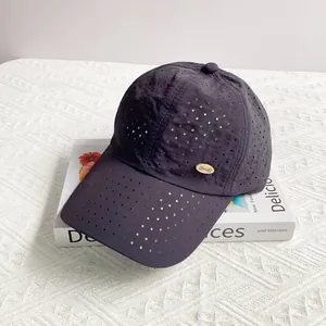 Detail of laser-cut perforated vents and gold oval logo on quick-dry baseball cap
