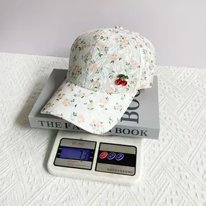 Close-up of floral lace sun hat with cherry rhinestone detail and breathable fabric