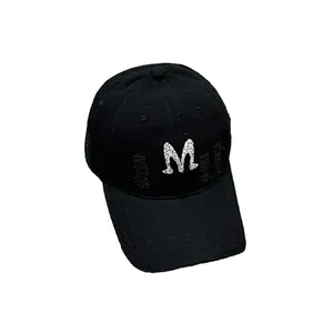 Distressed black cotton baseball cap with a sparkling silver letter M rhinestone decoration