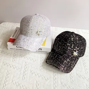 Detailed view of lace baseball caps with rhinestone star patterns and floral accents