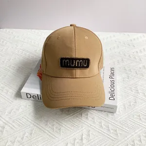 Detail showing mumu brand patch and stitching on khaki cotton baseball cap crown