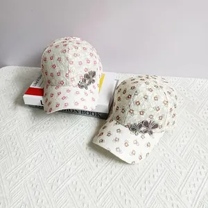 Detail of pink and brown lace baseball caps featuring diamond patterns and rhinestone butterflies