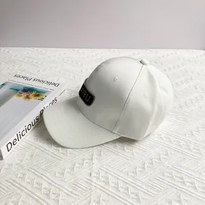 Detail of white baseball cap with rhinestone mumu logo on premium pineapple fabric
