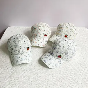 Detail showing lace mesh baseball caps with floral patterns and cherry charms in four colors