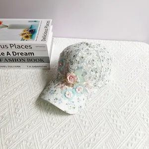 Détails de fleurs 3D et perles sur casquette en dentelle blanche à motif floral