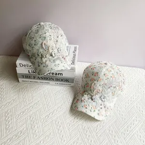 Close-up of floral lace baseball caps with 3D iris flowers and pearl bead details