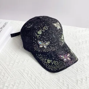 Detailed macro of black lace baseball cap with iridescent rhinestone butterfly and Love motif