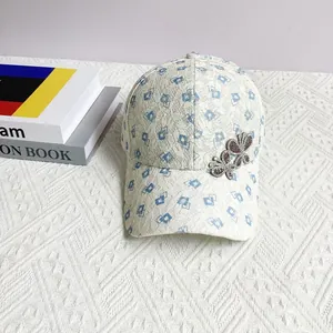 Close-up of lace baseball cap featuring blue diamond patterns and rhinestone butterflies