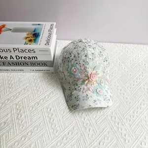 Détail des fleurs 3D faites à la main avec perles sur une casquette en dentelle blanche