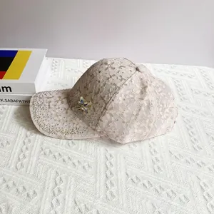 Close-up of pink lace baseball cap featuring rhinestones and a purple butterfly brooch