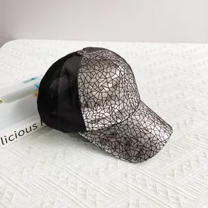 Macro detail of silver cracked pattern panel and black mesh on a hip-hop baseball cap