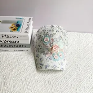 Détail d'une casquette en dentelle florale avec fleurs 3D faites main et perles