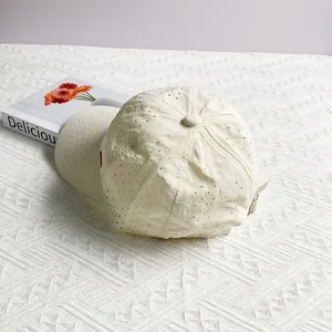 Close-up of off-white baseball cap showing laser-cut breathable ventilation holes