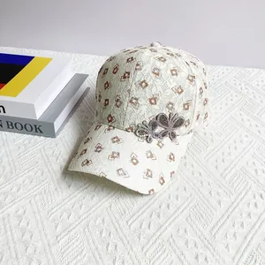 Detail of white lace baseball cap featuring brown diamond patterns and rhinestone butterflies