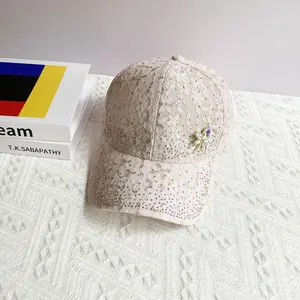 Detailed view of pink lace baseball cap featuring shimmering rhinestones and a floral brooch