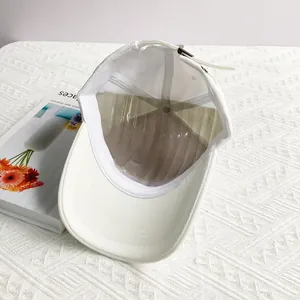 Inside view of white baseball cap showing metal buckle strap and inner canvas texture