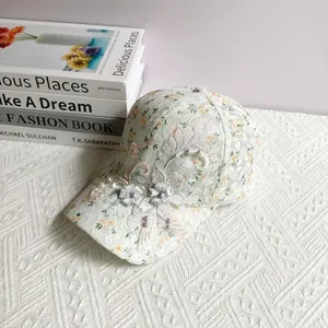 Detail of white lace baseball cap with floral print, 3D embroidery and pearl accents